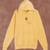 Yellow hoodie with a small black logo on a brown background