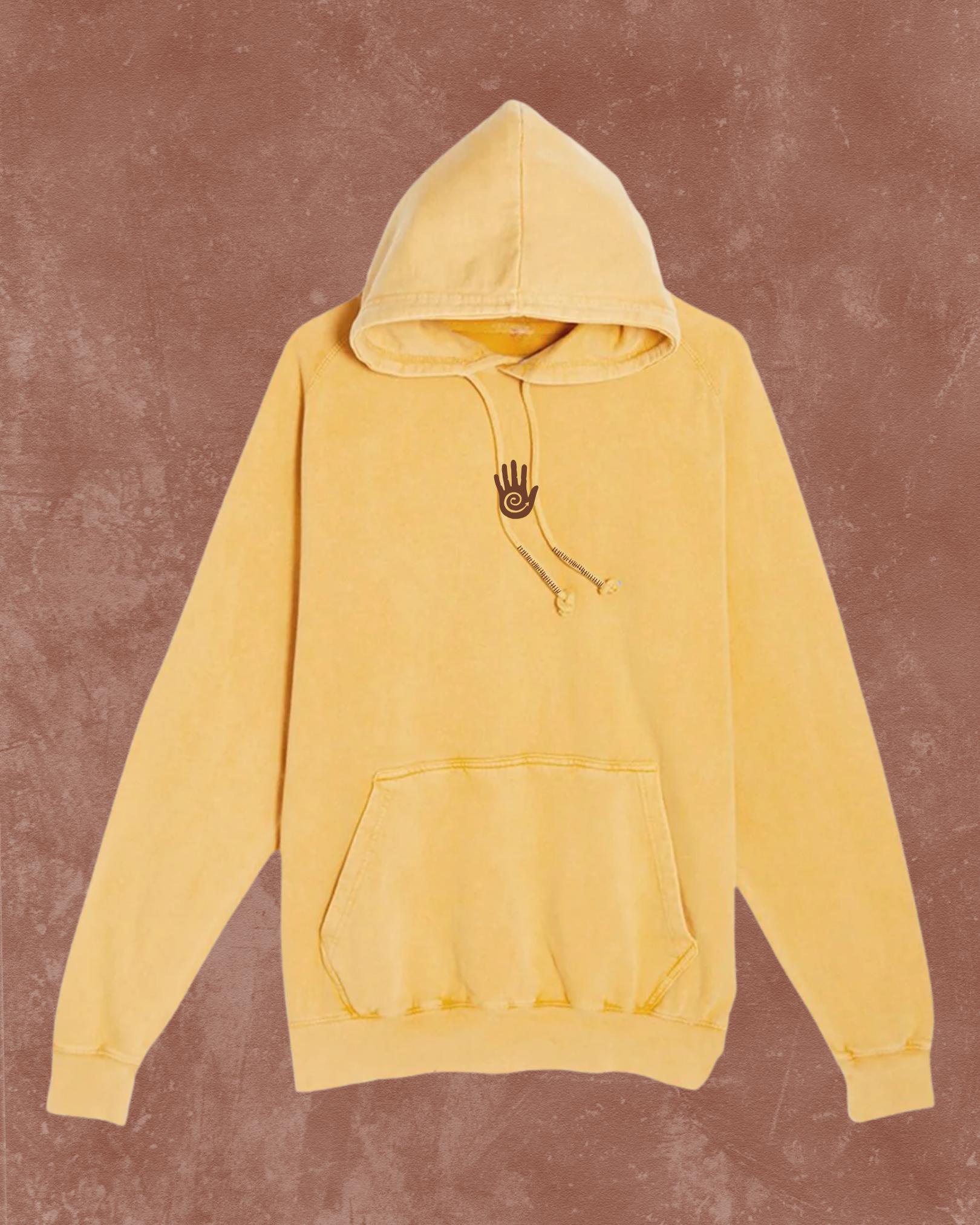 Yellow hoodie with a small black logo on a brown background