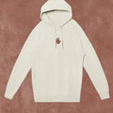 White hoodie with a small logo on a textured brown background