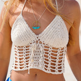 Woman wearing a crochet top and blue shorts on a beach