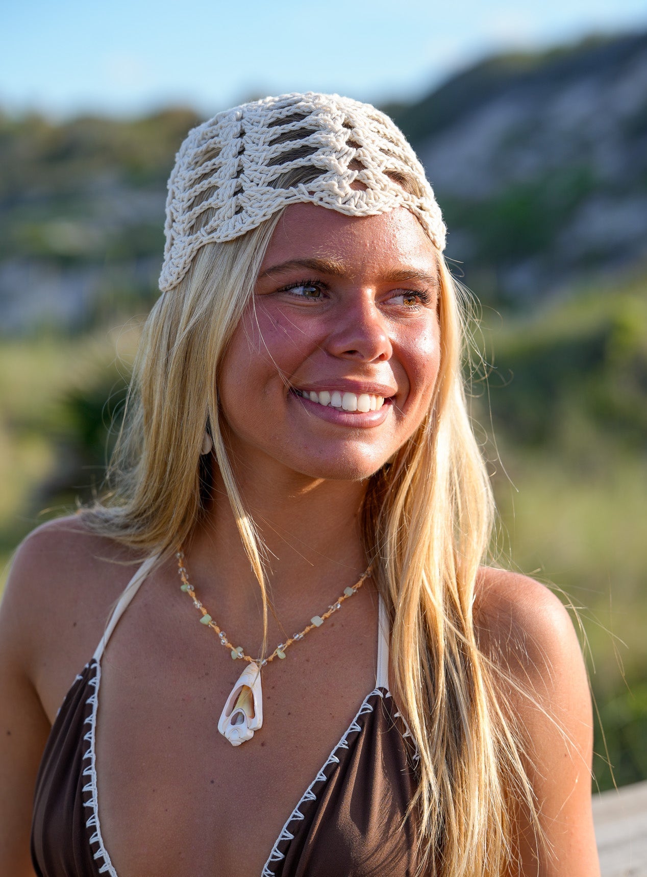 Woman wearing a crochet cap and bikini top outdoors